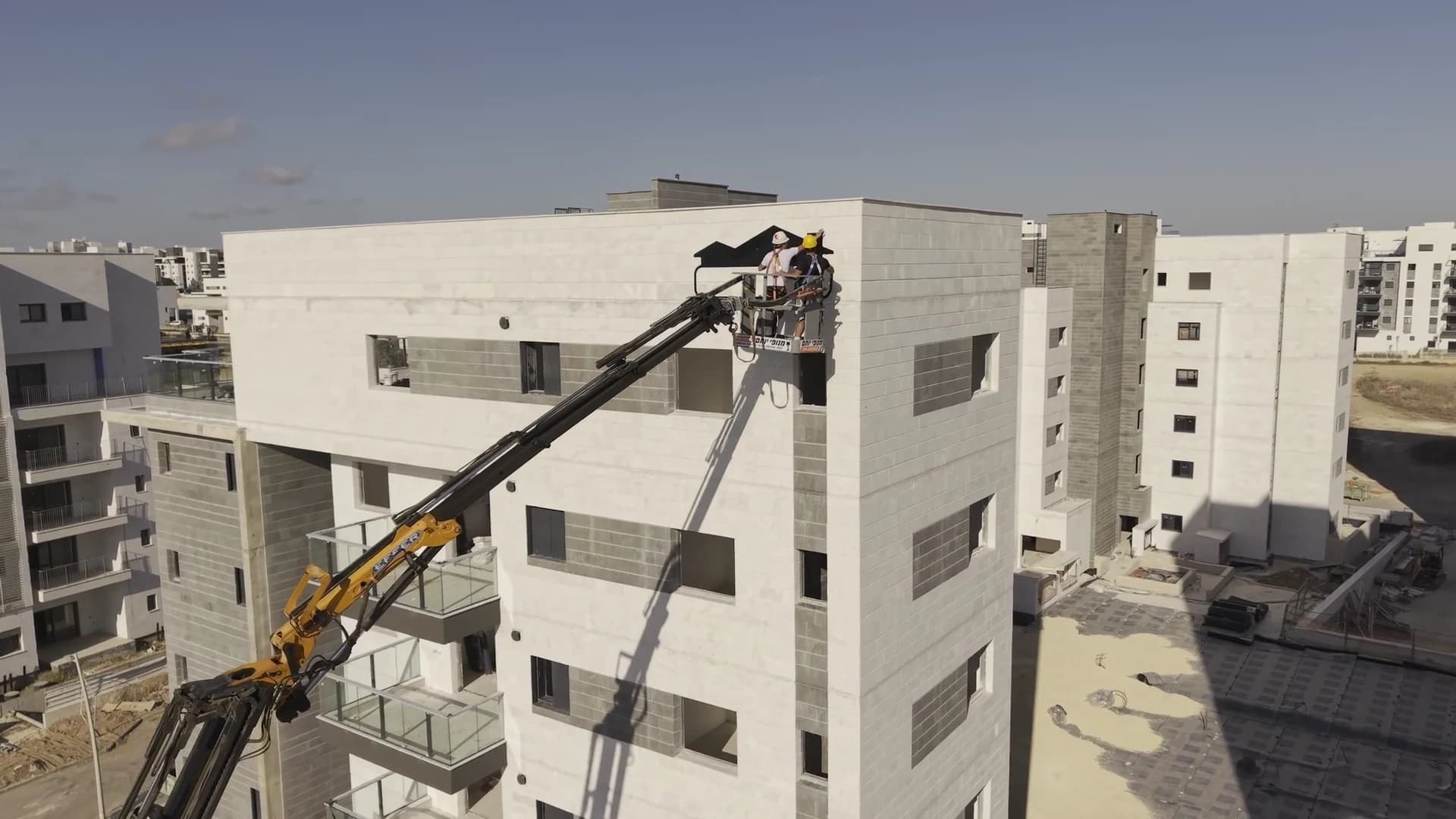 עבודת שילוט בחזית בניין מתוך סל מנוף ממותג מנופי יותם